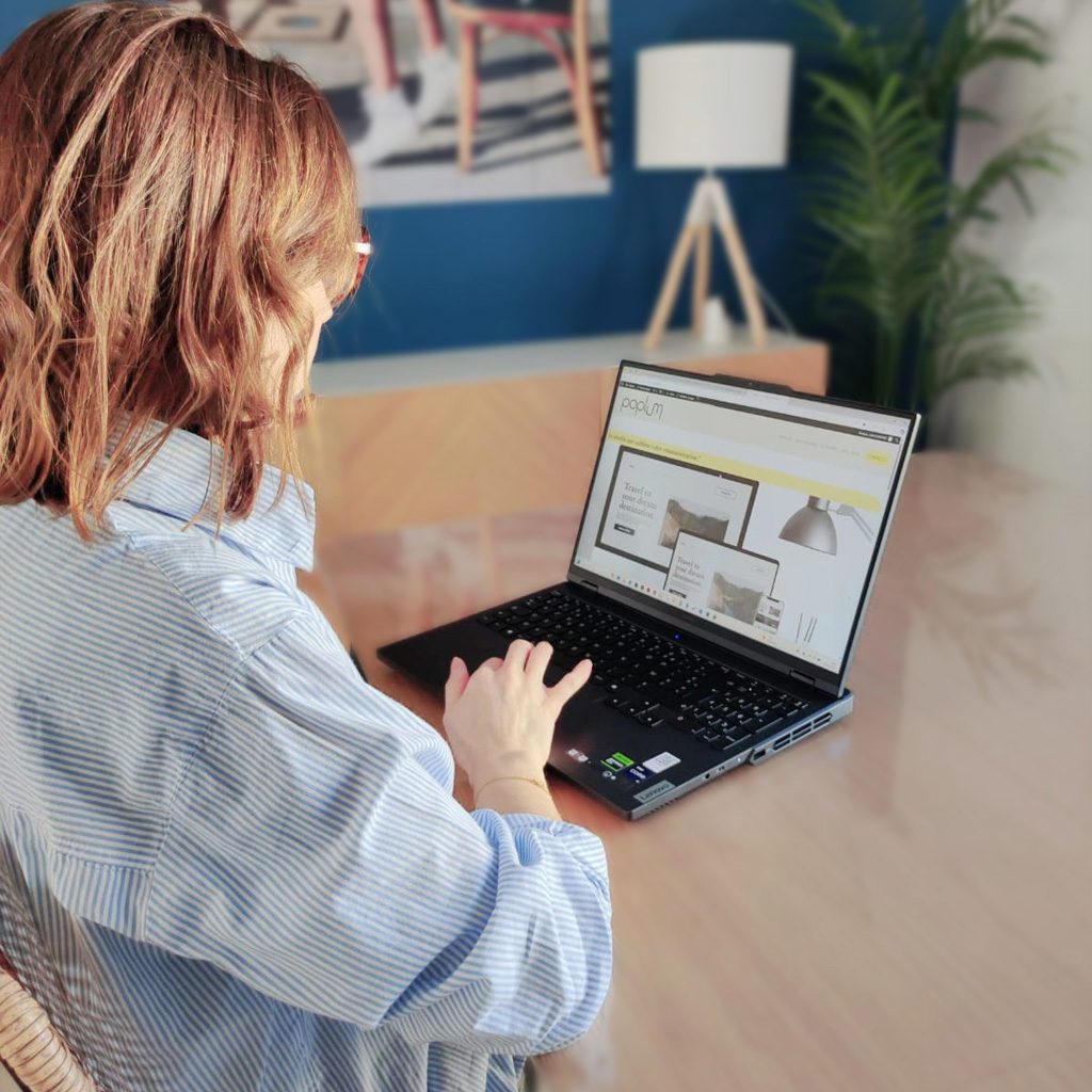 Julie, graphiste freelance, travaillant de dos sur son ordinateur portable dans son studio